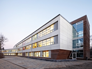 Durch eine vorgehängte hinterlüftete Fassade mit Bekleidung aus Faserzement in der Materialkombination mit Douglasienholz besticht die erste CO2-neutrale Schule Hamburgs auch durch ihr Erscheinungsbild. Foto: Meike Hansen / Eternit