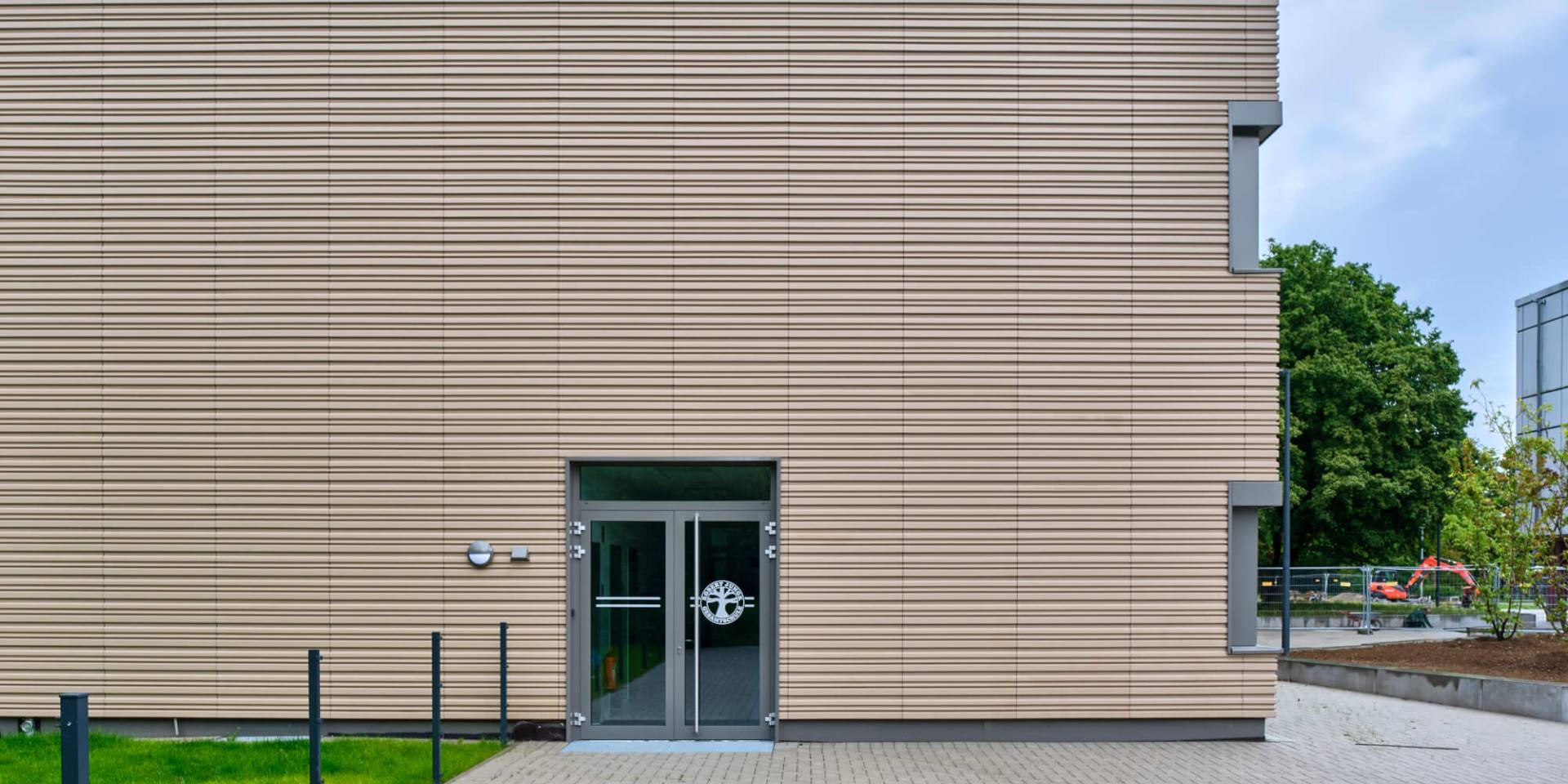 Tonality Referenz Gesamtschule Krefeld: Keramikfassade an Gebäudeecke mit abwechselnden Terrakotta-Tönen und lebendiger Strukturierung