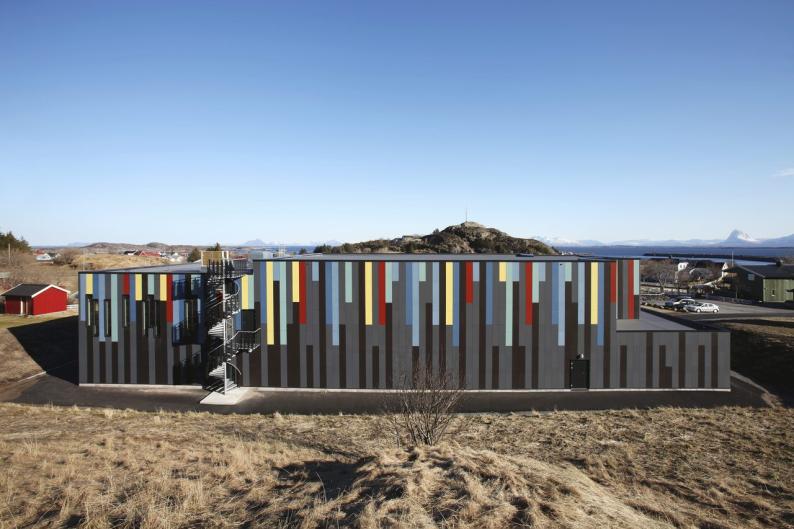 Trotz seiner Größe fügt sich das Gebäude wie selbstverständlich zwischen die kleinen Holzbauten des Dorfes ein.  Foto: Bent Rannes Sorensen