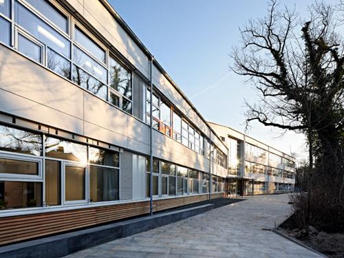 Der zentrale Eingangsbereich und die darüber liegenden Unterrichtsräume  in Holztafelbauweise sind farblich mit hellen EQUITONE Fassadentafeln zurückhaltend gestaltet. Foto: Meike Hansen, Hamburg
