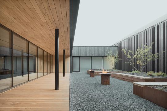 Ein Innenhof als kontemplativer Rückzugsort: Holz, Stahl und verglaste Flächen harmonieren mit den differenziert bekleideten Fassaden. Foto: Brigida González