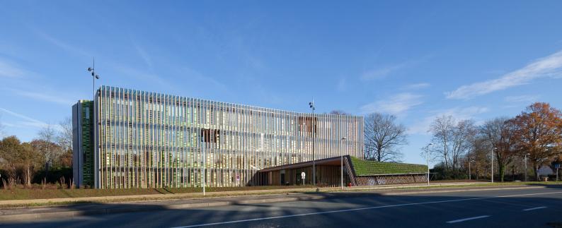Grüne Architektur ist nicht nur inhaltlich, sondern wörtlich zu nehmen: Das niedrige Eingangsgebäude vor dem Riegel hat ein bepflanztes Dach und Teil des Klimakonzeptes. Foto: Mathieu Choiselat / Patrick Arotcharen