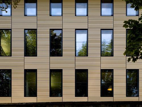 Die hoch-wärmegedämmte Fassade ist mit profilierten Keramikplatten bekleidet, die in Verbindung mit einer fassadenbündigen Verglasung die skulpturale Präsenz des Baukörpers herausstellen. Foto: MOEDING Keramikfassaden GmbH (Stefan Müller-Naumann, München)