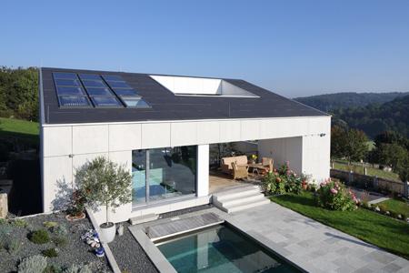 Als natürliches Material mit besonderer Struktur und Haptik wählten die Architekten Faserzement. Damit entstand eine Gebäudehülle aus einem Guss: Die komplette Fassade inklusive Garagentor, die Deckenuntersichten sowie die Dachhaut sind mit großformatigen EQUITONE Tafeln gestaltet.  Foto: Conné van d´Grachten