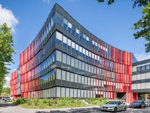 Die vorgehängte hinterlüftete Fassade aus Glaselementen sorgt für wandelbare Farb-Effekte. Foto: Hanno Keppel, Lithodecor  