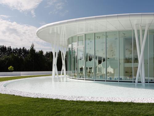 Wasser, Glas und die vorgehängte hinterlüftete Fassade mit weißen Alucubondtafeln sorgen für die elegante Anmutung des Pavillons.  Foto: 3A Composites