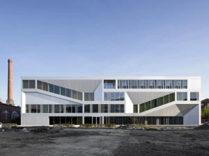 Die innere Raumorganisation ist an den beiden Längsfassaden ablesbar und setzt so Außen und Innen des kompakten Baukörpers miteinander in Beziehung.  Foto: Werner Huthmacher, Berlin