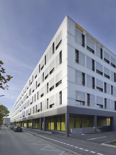 Auf die extremen Lärmbelastungen der exponierten Lage zwischen einer  sechsspurigen Ausfahrtstraße und einer Bahntrasse reagierten die  Architekten mit einer bemerkenswerten, transluzenten VHF. Der Gewerbehof bietet 50 bis 70 Start-up-Unternehmen kostengünstige Produktions- und Verkaufsräume.   Foto: Julia Knop, Hamburg 